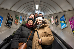 Kuba team mates smile on a London Underground escalator